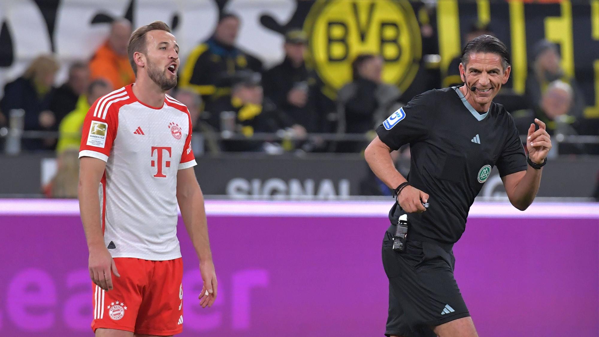 Harry Kane ruft Schiedsrichter Deniz Aytekin etwas zu, der lacht.