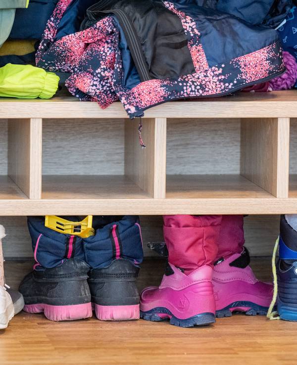 Das Foto zeigt Schuhe und Jacken im Eingangsbereich eines Kindergartens.