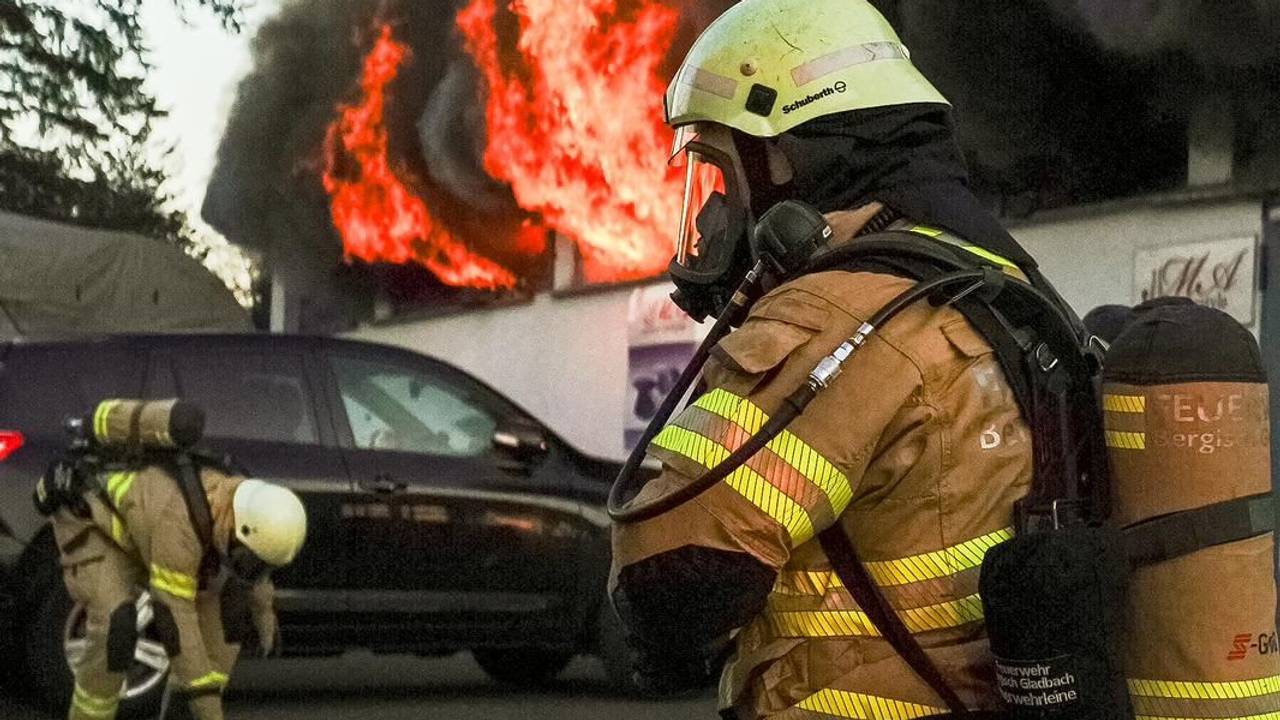 Feuerwehrleute kämpfen gegen einen Brand in einer Lagerhalle in Bergisch Gladbach.