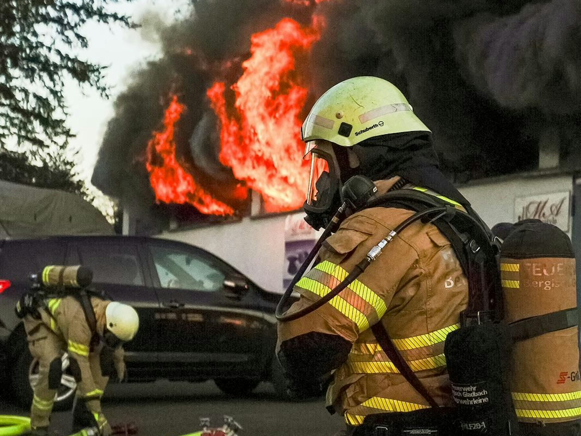 Feuerwehrleute kämpfen gegen einen Brand in einer Lagerhalle in Bergisch Gladbach.