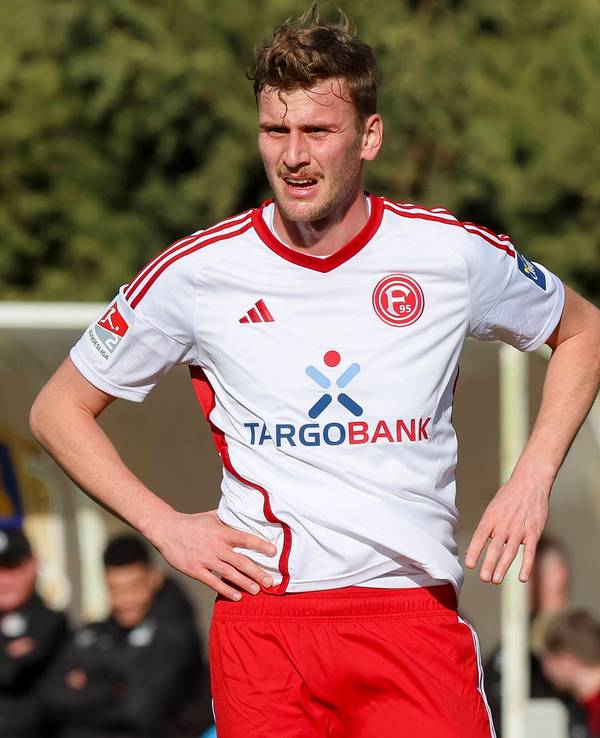 Fortuna Düsseldorfs Christoph Daferner steht auf dem Platz und schaut enttäuscht.