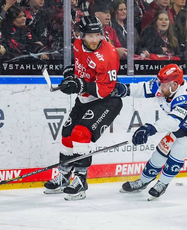 Tylor Spink versucht Kölns Frederik Storm (l.) den Puck abzunehmen.