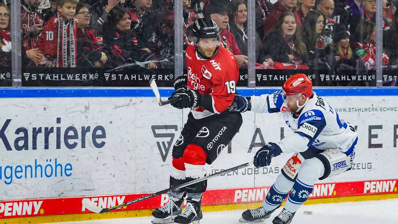 Tylor Spink versucht Kölns Frederik Storm (l.) den Puck abzunehmen.