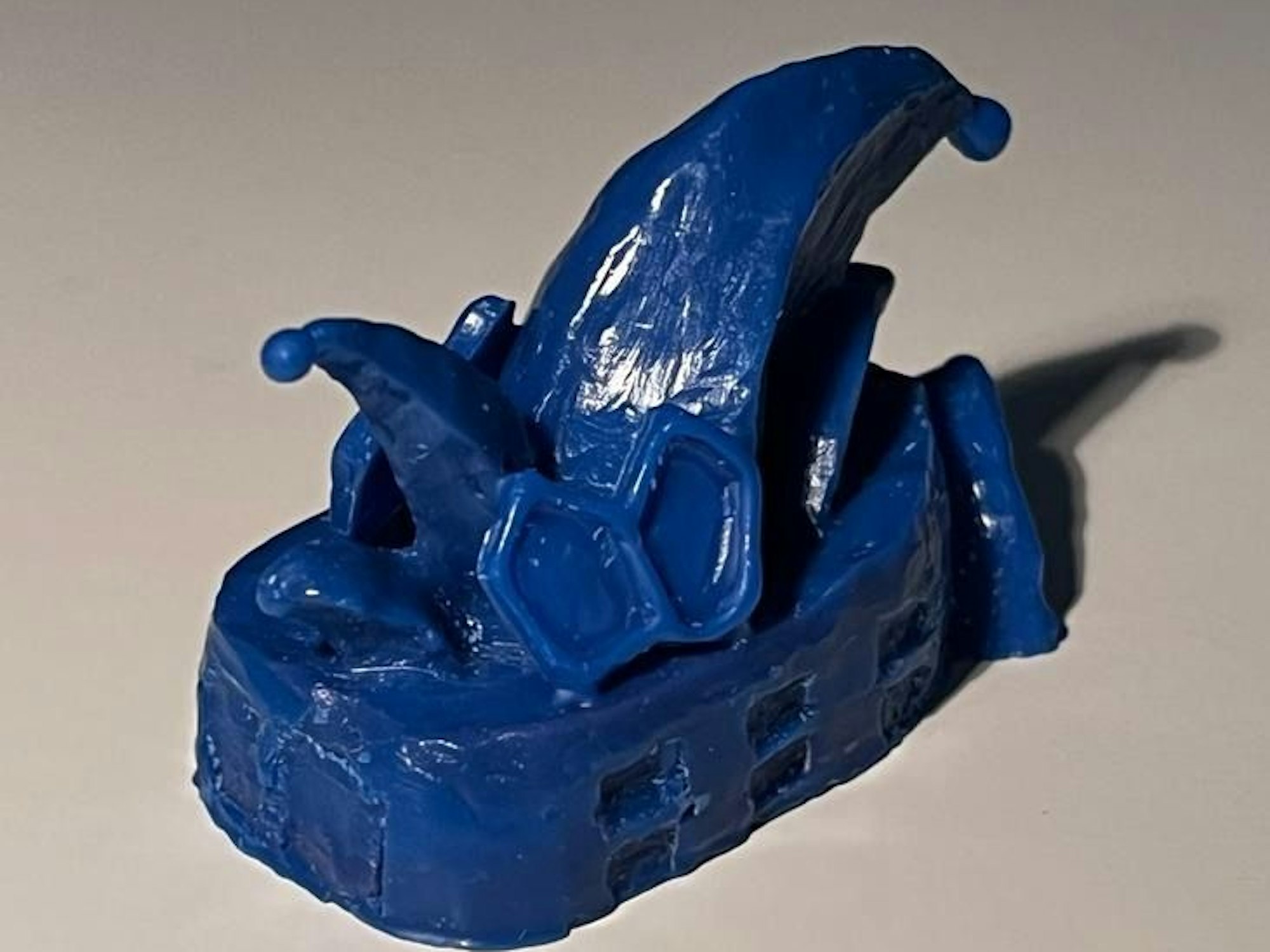 Blaues Modell aus Zahnwachs auf beigem Untergrund.