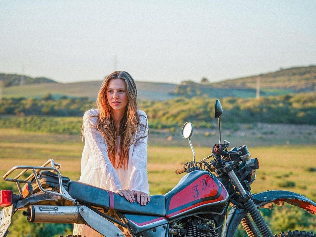 Ann-Kathrin Bendixen aka Affe auf Bike lehnt sich auf ihr Motorrad.