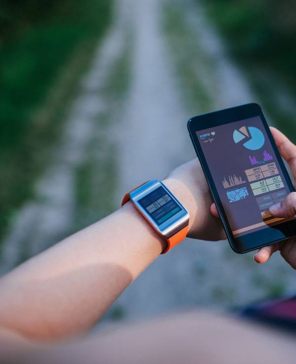 Eine Frau synchronisiert ihre Smartwatch mit ihrem Handy.