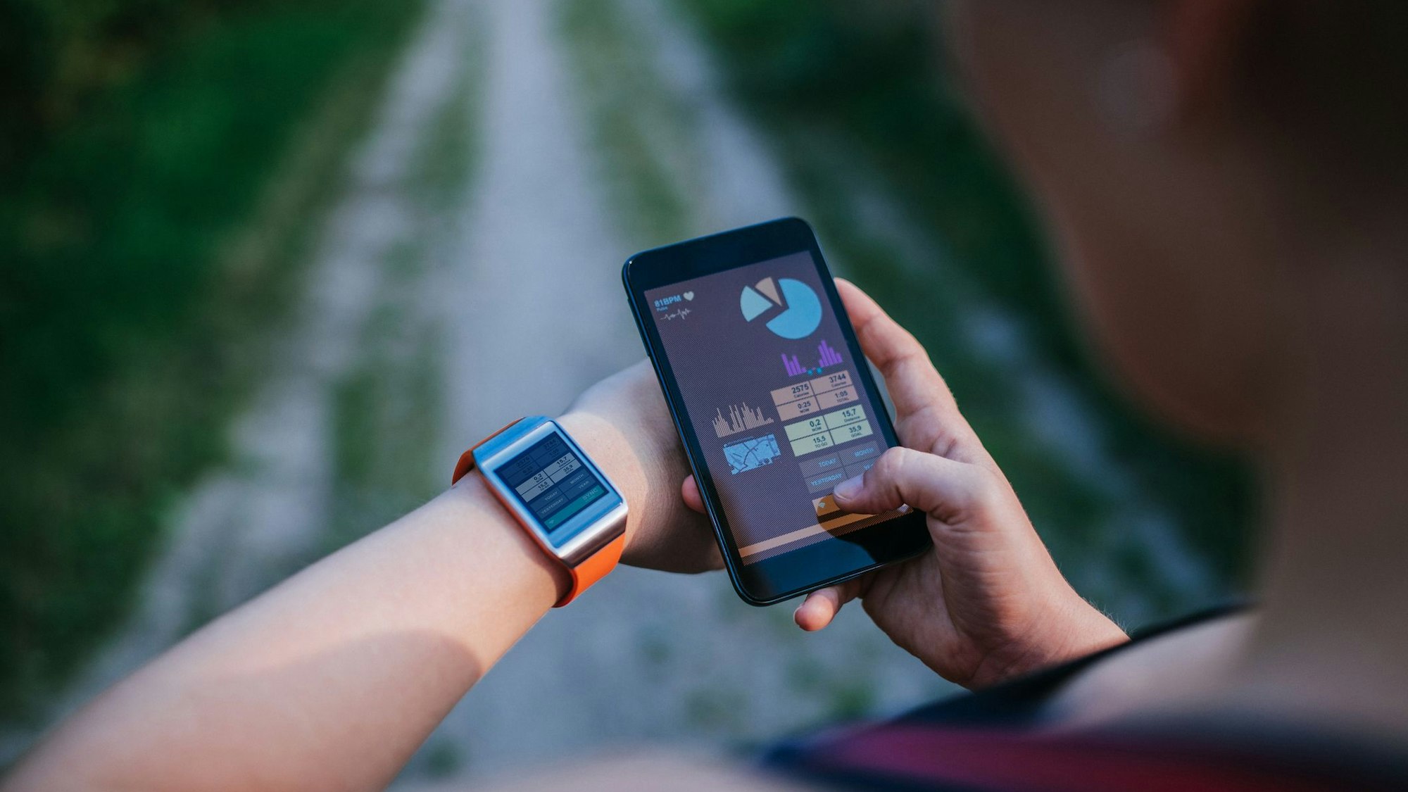 Eine Frau synchronisiert ihre Smartwatch mit ihrem Handy.