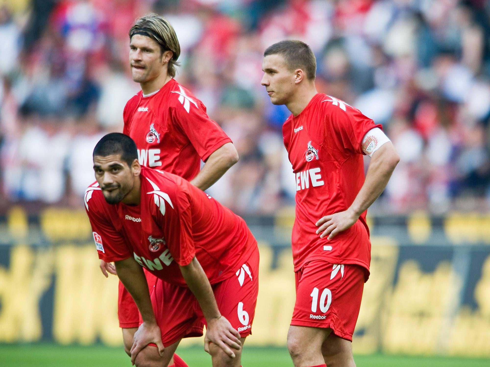 Taner Yalcin, Lukas Podolski und Martin Lanig stehen nach einer Niederlage des 1. FC Köln auf dem Rasen.