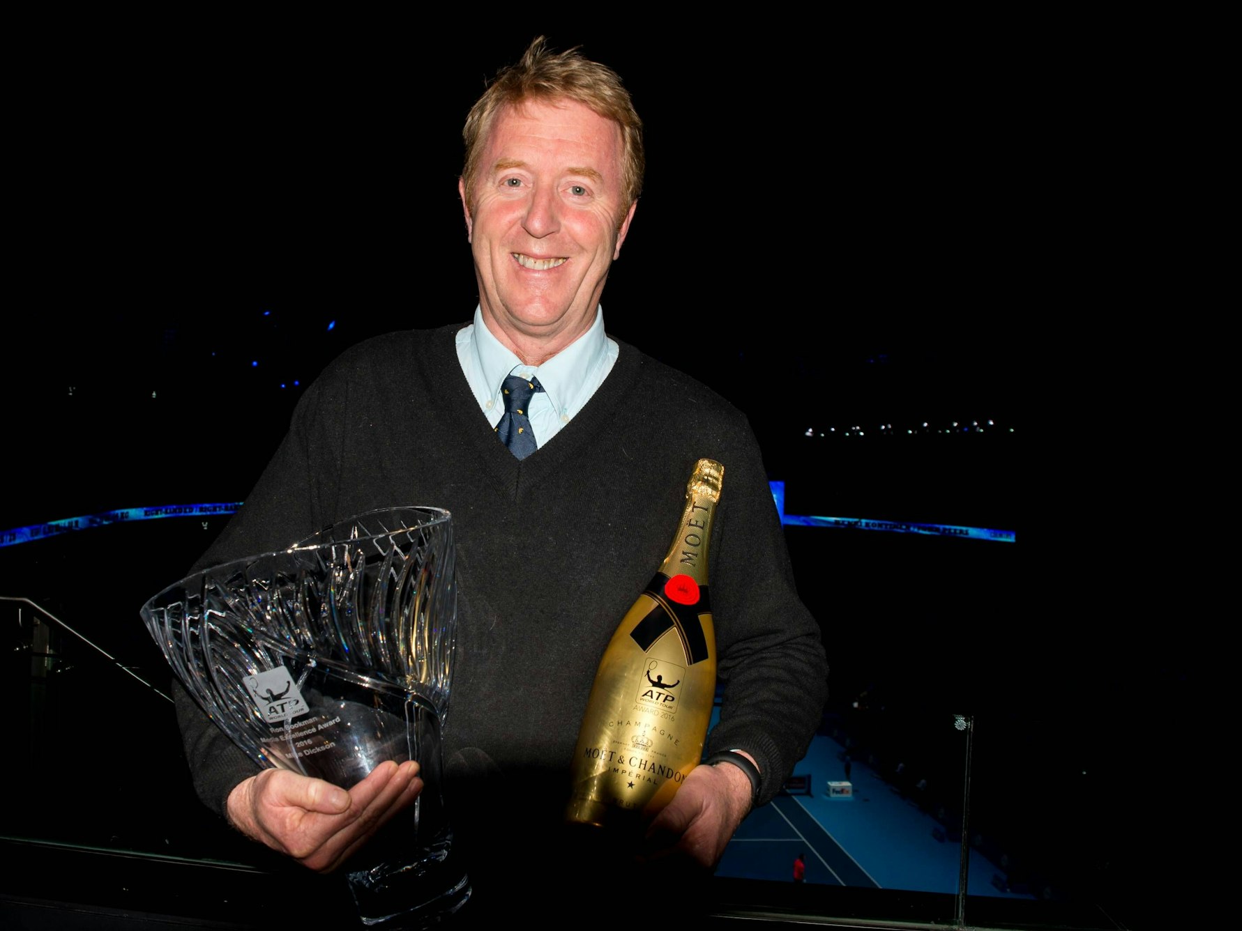 Mike Dickson hält den Ron Bookman Media Excellence Award und eine Flasche Champagner in den Händen.