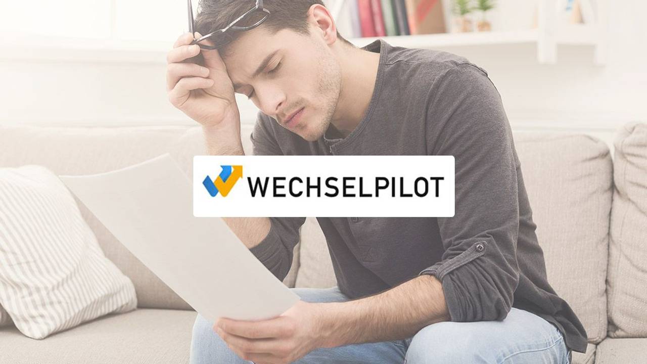 Mann sitzt erschöpft beim Lesen eines Schriftstückes auf der Couch. Logo von Wechselpilot im Bild.