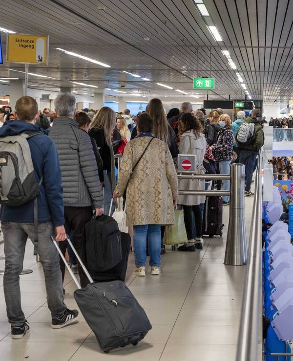 Reisende drängen sich am Flughafen Schiphol an den Gates.