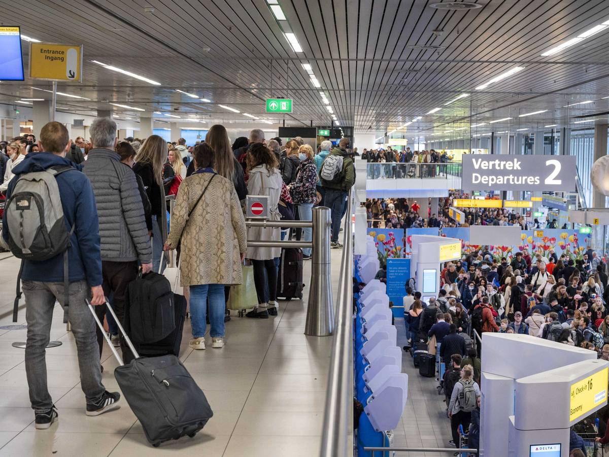 Reisende drängen sich am Flughafen Schiphol an den Gates.