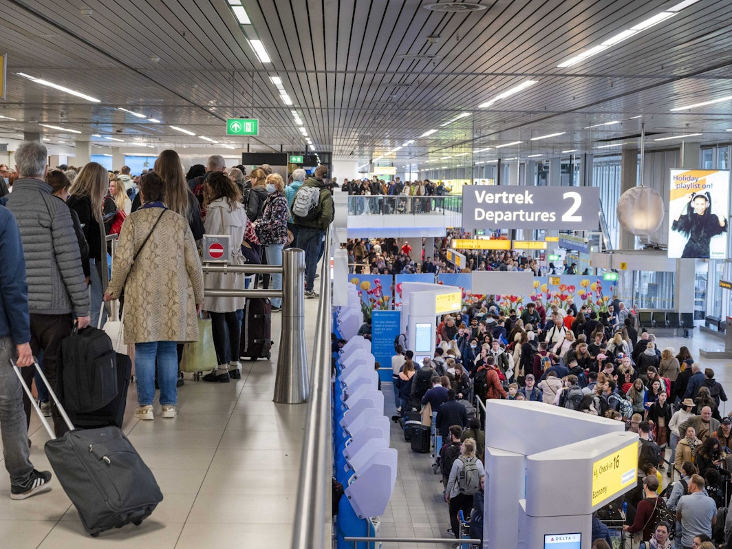 Reisende drängen sich am Flughafen Schiphol an den Gates.