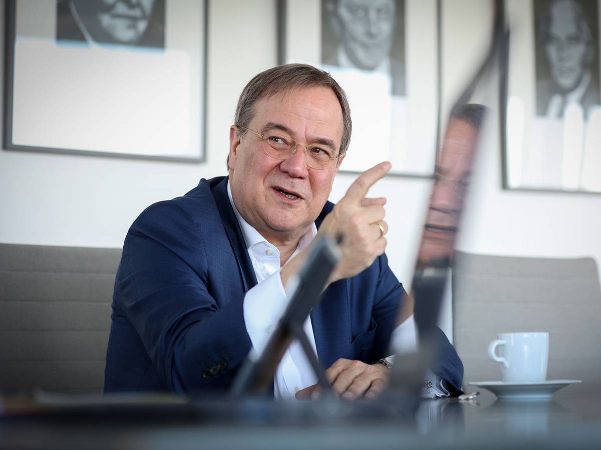 Armin Laschet sitzt im Anzug bei einem Interview und gestikuliert mit seinem Zeigefinger.