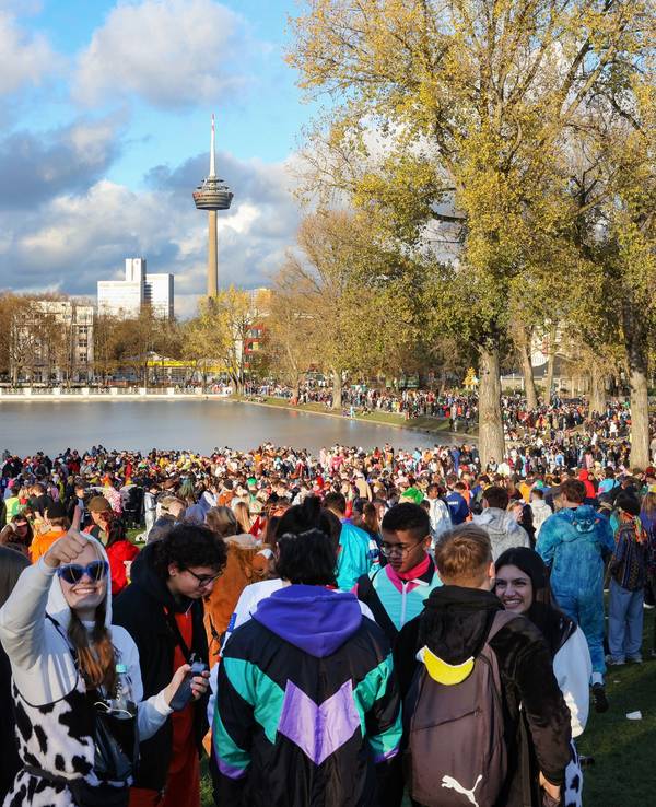 Tausende Menschen stehen verkleidet rund um den Aachener Weiher in Köln und feiern Karneval.