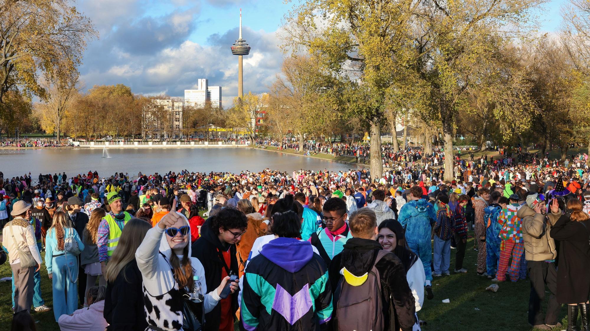 Tausende Menschen stehen verkleidet rund um den Aachener Weiher in Köln und feiern Karneval.