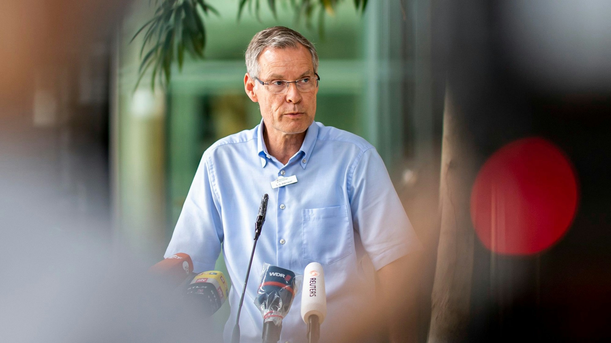 Sven-Georg Adenauer spricht während einer Pressekonferenz vor diversen Mikrofonen.