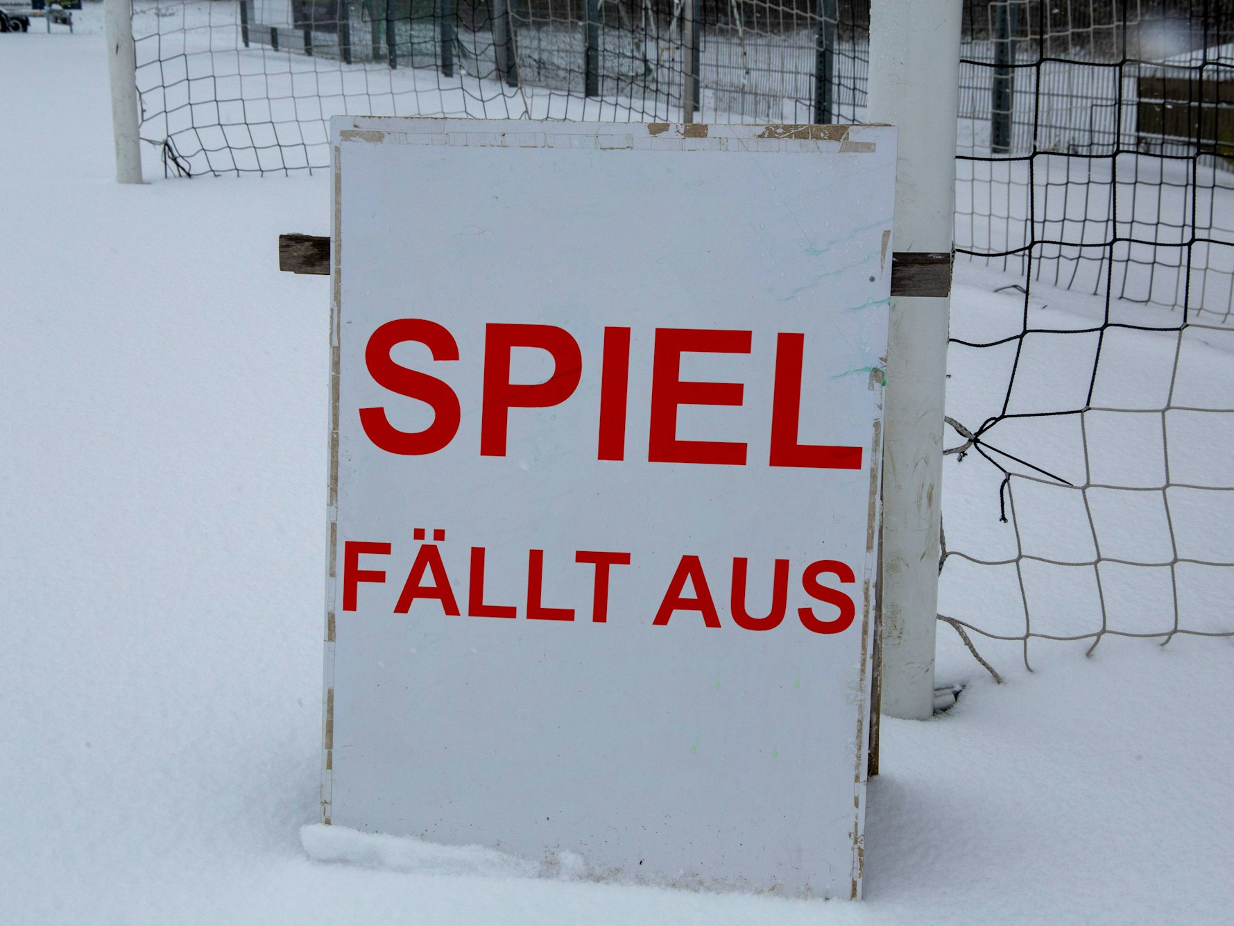 Schild auf einem Sportplatz mit der Aufschrift „Spiel fällt aus“.