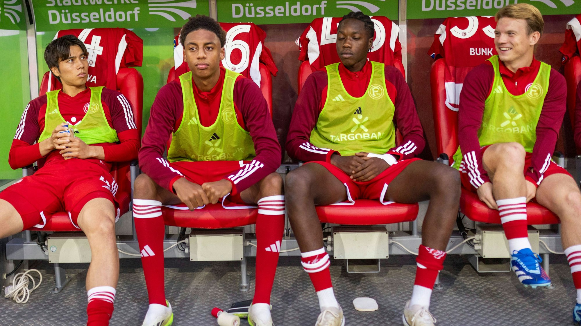 Von links nach rechts: Ao Tanaka, Sima Suso, King Manu und Daniel Bunk sitzen auf der Bank.
