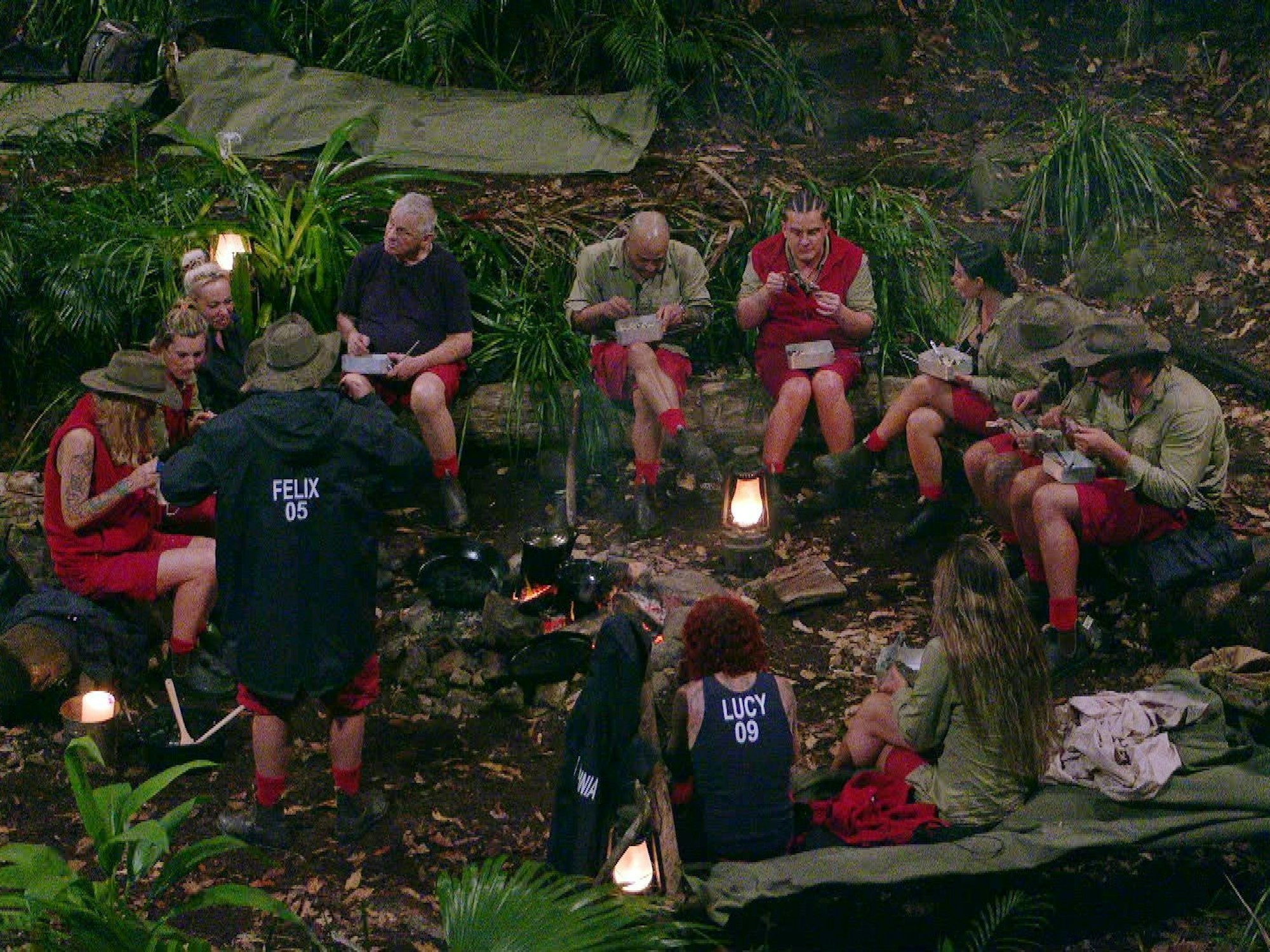 Alle 12 Kandidatinnen und Kandidaten sitzen um das Feuer im RTL-Dschungelcamp „Ich bin ein Star - holt mich hier raus“