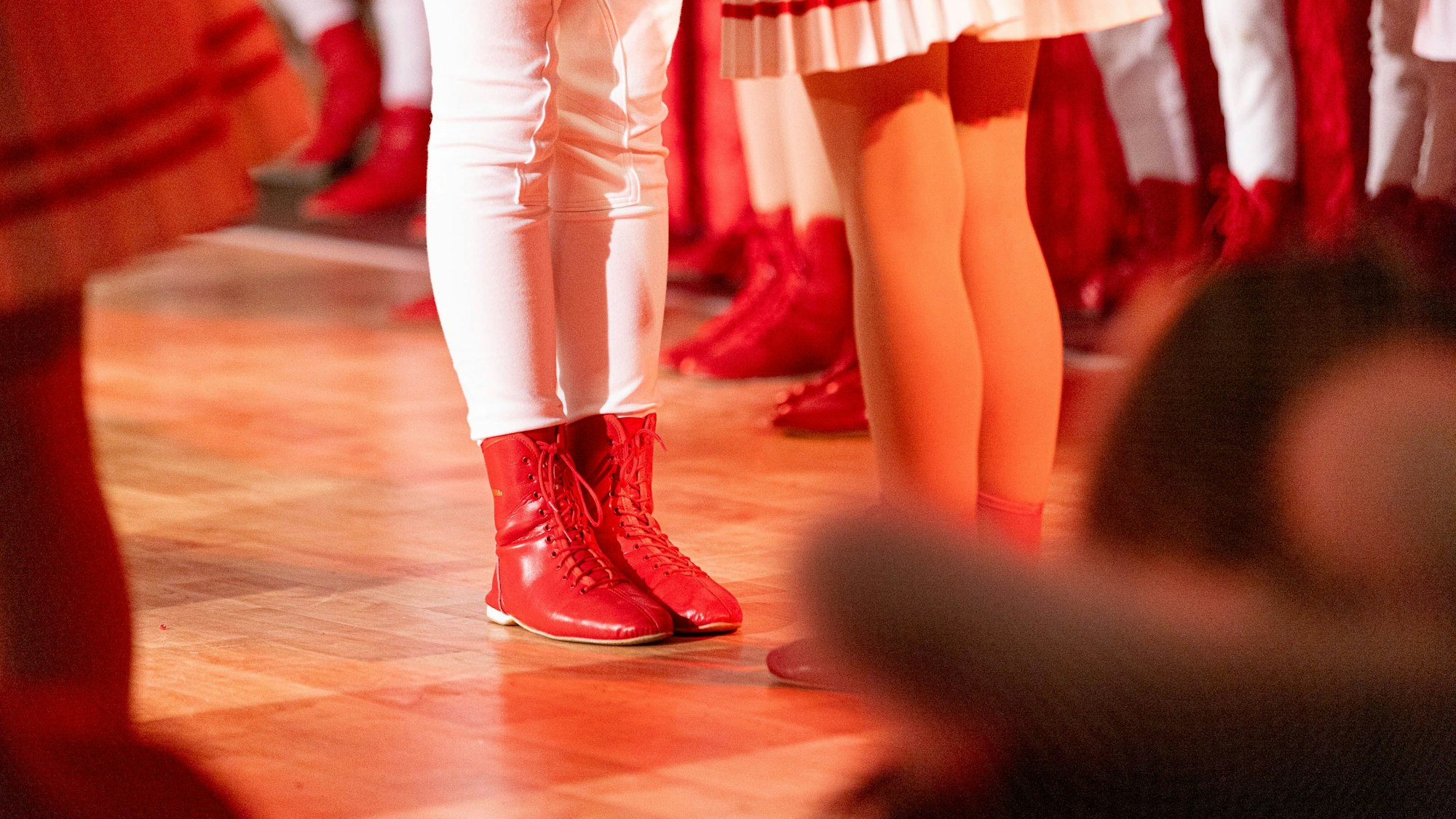 Die Füße eines Tänzers und einer Tänzerin sind auf der Bühne einer Karnevalssitzung zu sehen.