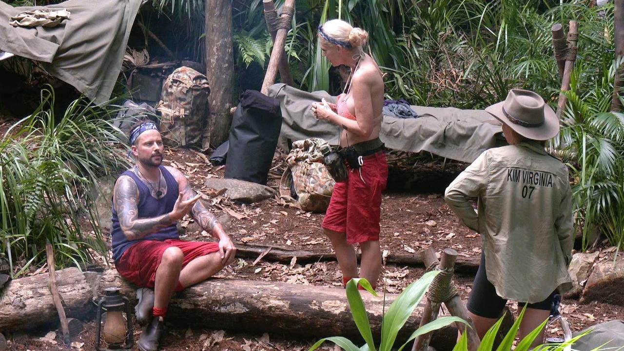 Felix von Jascheroff und Sarah Kern diskutieren im Dschungelcamp 2024. Kim Virginia hört zu.