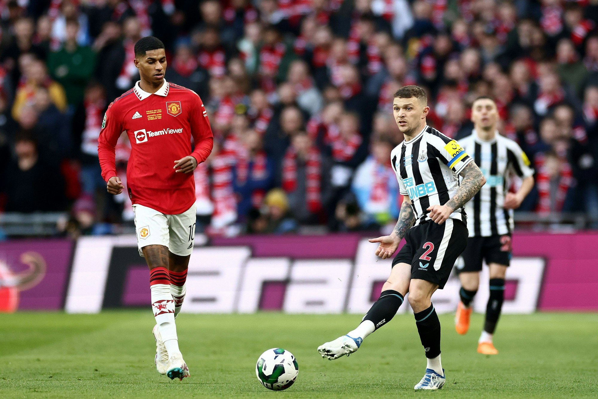 Kieran Trippier von Newcastle United nach einem Pass, links daneben Marcus Rashford von Manchester United.