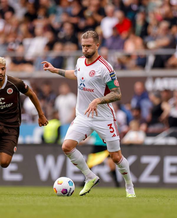Fortuna Düsseldorfs Kapitän Andre Hoffmann passt den Ball, im Hnitergrund läuft St. Paulis Elias Saad.
