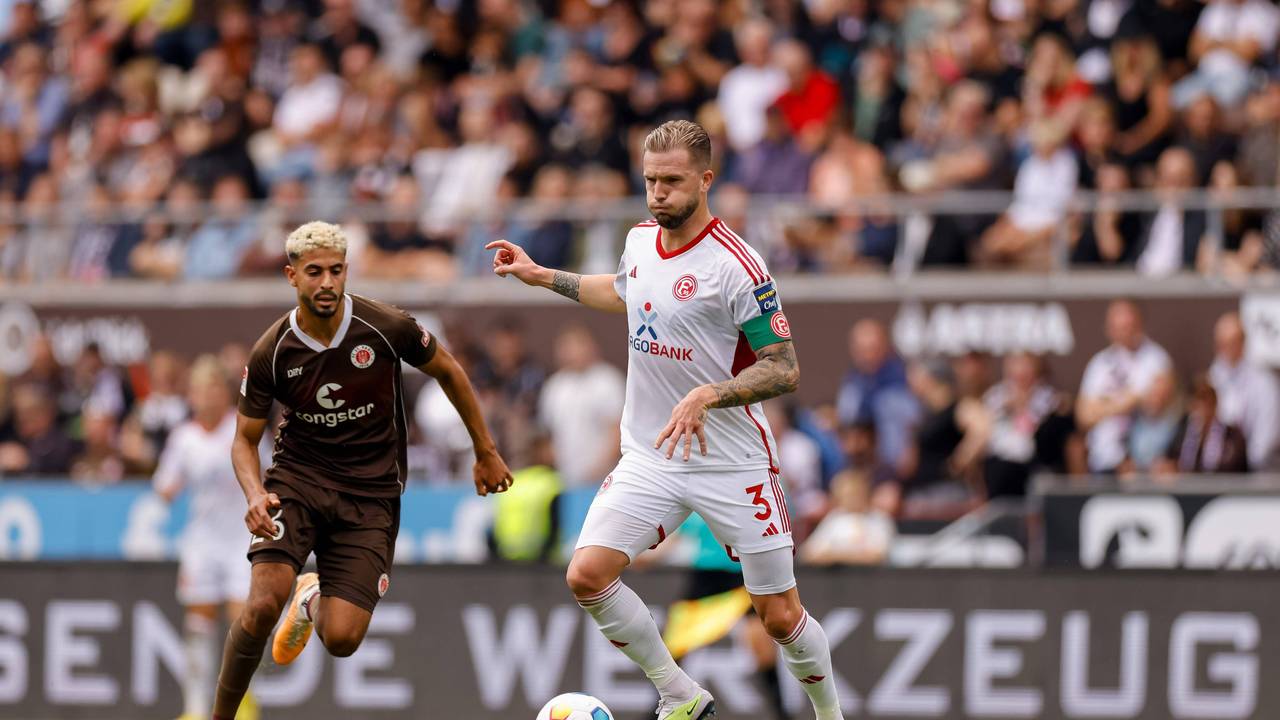 Fortuna Düsseldorfs Kapitän Andre Hoffmann passt den Ball, im Hnitergrund läuft St. Paulis Elias Saad.