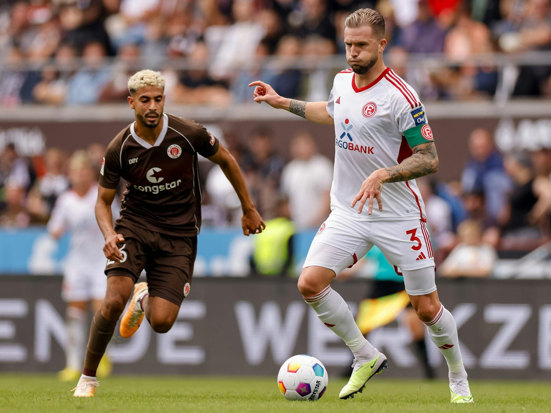 Fortuna Düsseldorfs Kapitän Andre Hoffmann passt den Ball, im Hnitergrund läuft St. Paulis Elias Saad.