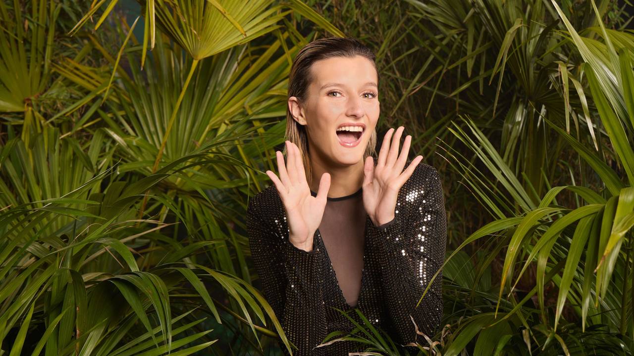 Das Foto zeigt die Dschungelcamp-Kandidatin Anya Elsner umgeben von Pflanzen.