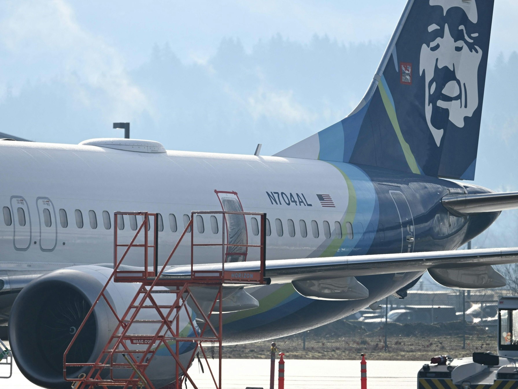 Eine Boeing 737-9 Max, die am 5. Januar auf dem Portland International Airport notgelandet ist, wird am 23. Januar 2024 in einer Wartungshalle in Portland, Oregon, abgestellt. Die fehlende Nottür ist abgedeckt und abgeklebt.