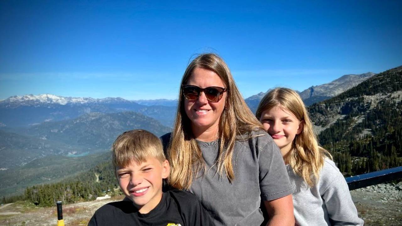 Anke Meider steht mit ihren beiden Kindern vor einem kanadischen Panorama.