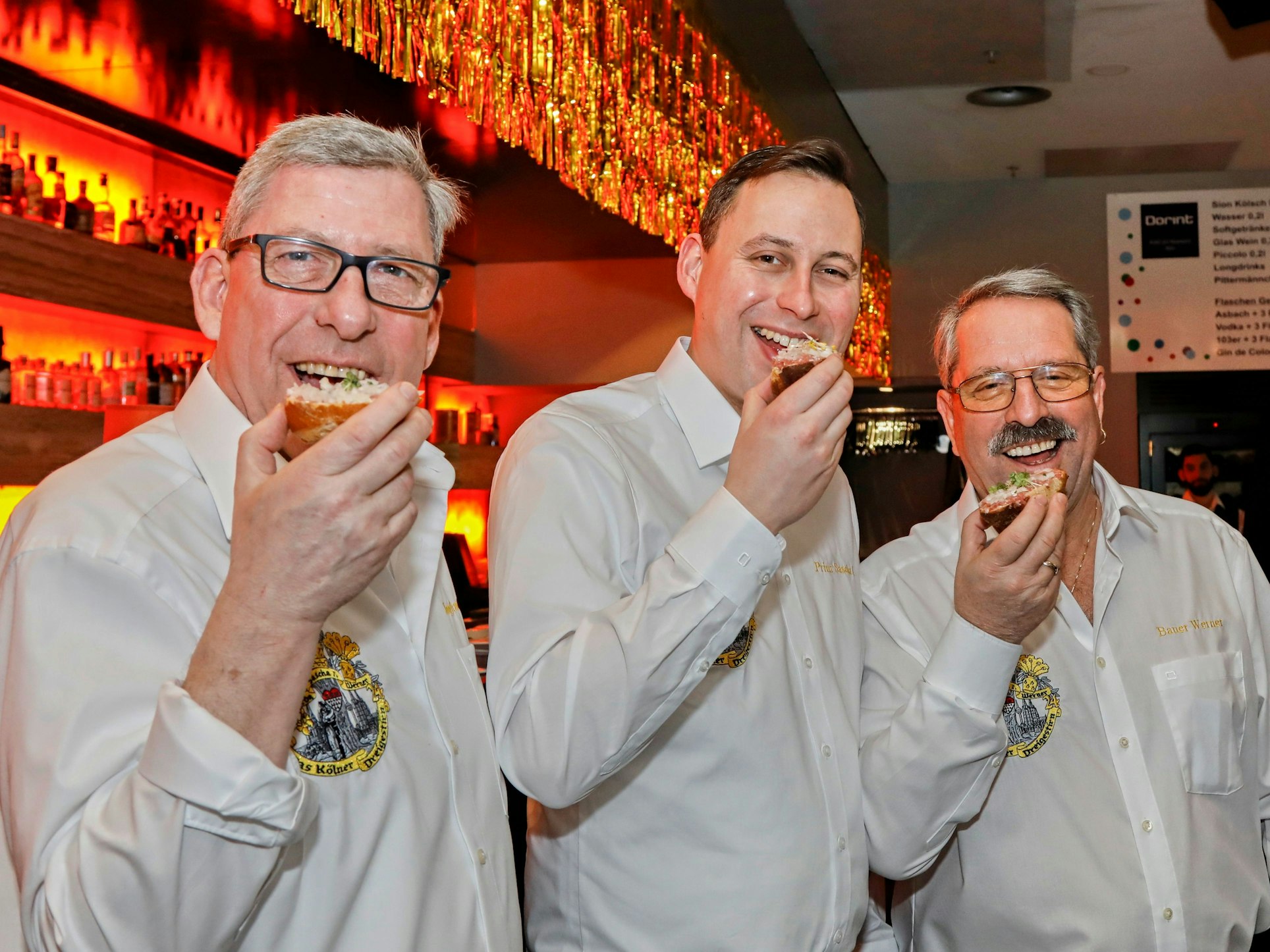 Das Dreigestirn beißt in Mettbrötchen.