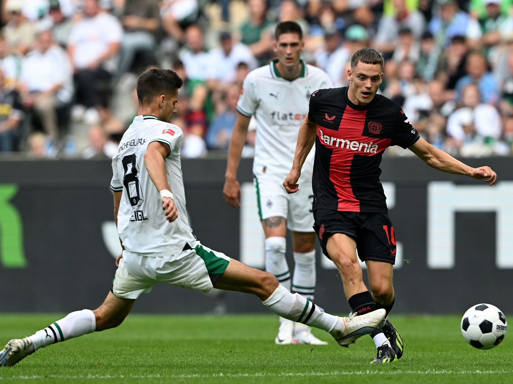 Mönchengladbachs Julian Weigl (l) und Leverkusens Florian Wirtz kämpfen um den Ball.