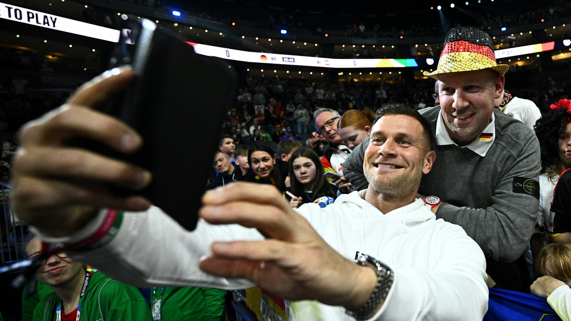 Mimi Kraus macht bei der Handball-EM ein Selfie mit einem Fan.