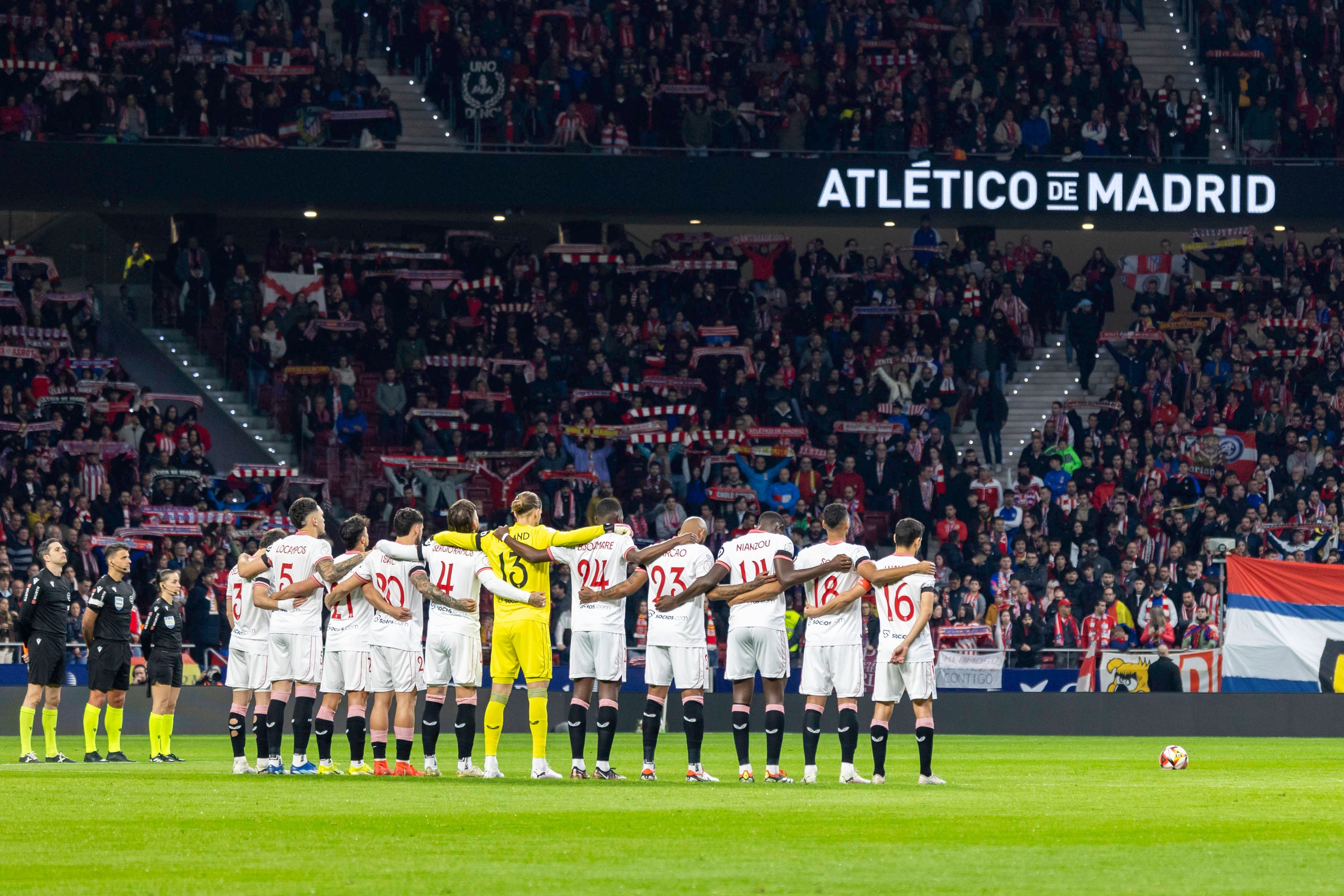 Die Spieler des FC Sevilla stehen Arm in Arm für eine Schweigeminute zusammen.