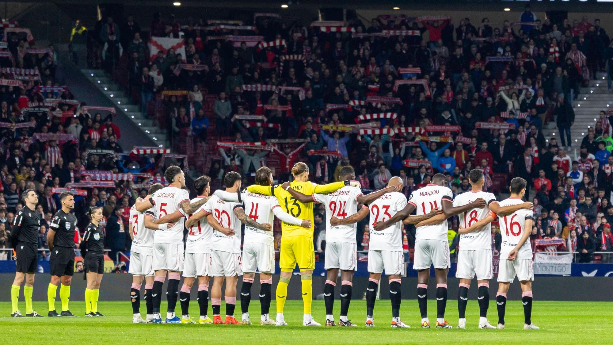 Die Spieler des FC Sevilla stehen Arm in Arm für eine Schweigeminute zusammen.