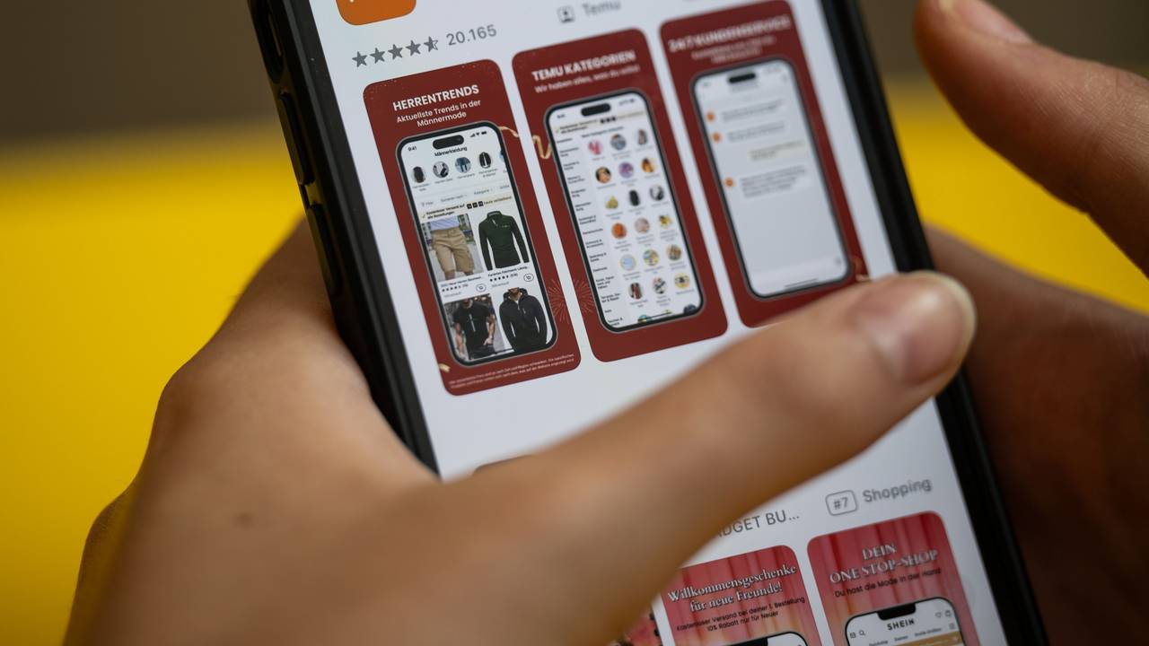 Eine Person hält ein Telefon mit der App Temu in den Händen (gestellte Szene).