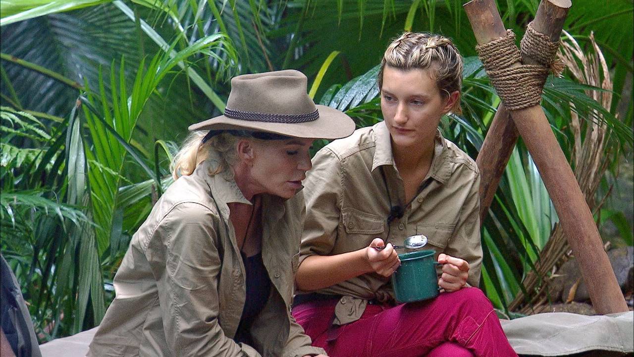 Sarah Kern und Anya Elsner sitzen auf einem Feldbett und unterhalten sich.