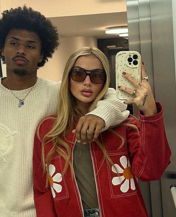 Loredana und Karim Adeyemi posieren zusammen für ein Spiegel-Selfie im Aufzug.