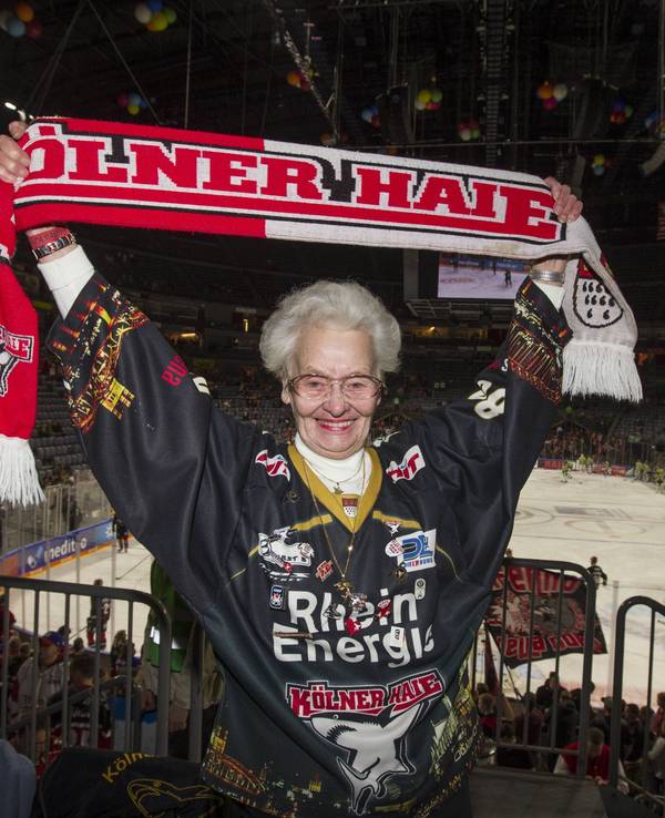 Käthe Stein mit KEC-Schal und Trikot auf der Tribüne der Lanxess-Arena.