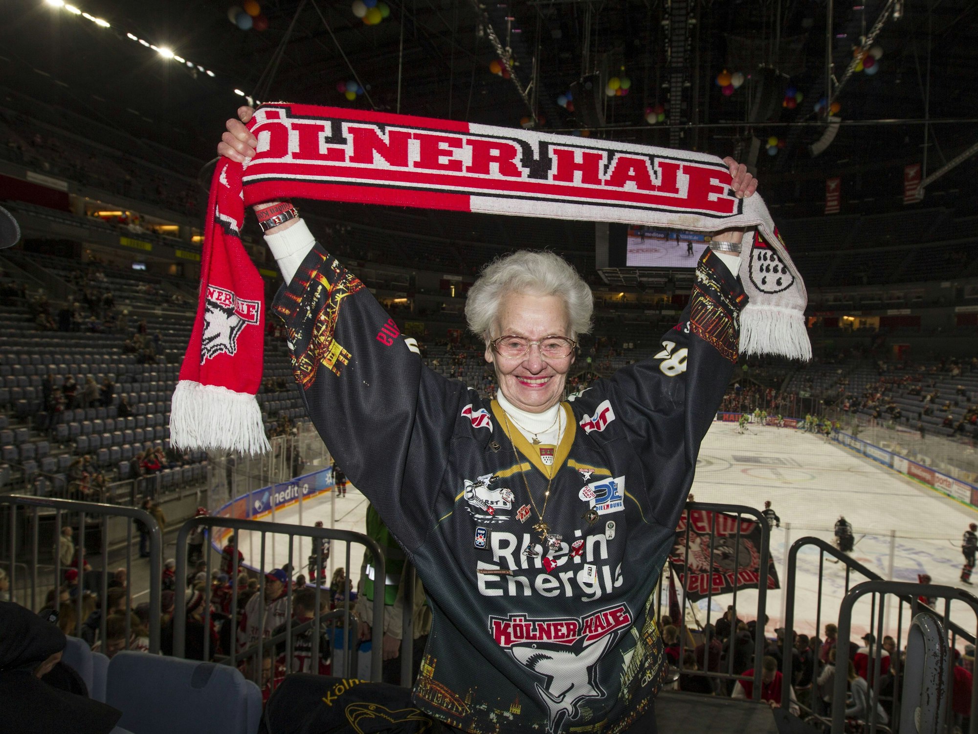 Käthe Stein mit KEC-Schal und Trikot auf der Tribüne der Lanxess-Arena.
