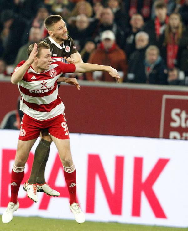 Fortuna Düsseldorfs Vincent Vermeij im Kopfballduell mit St. Paulis Karol Mets.