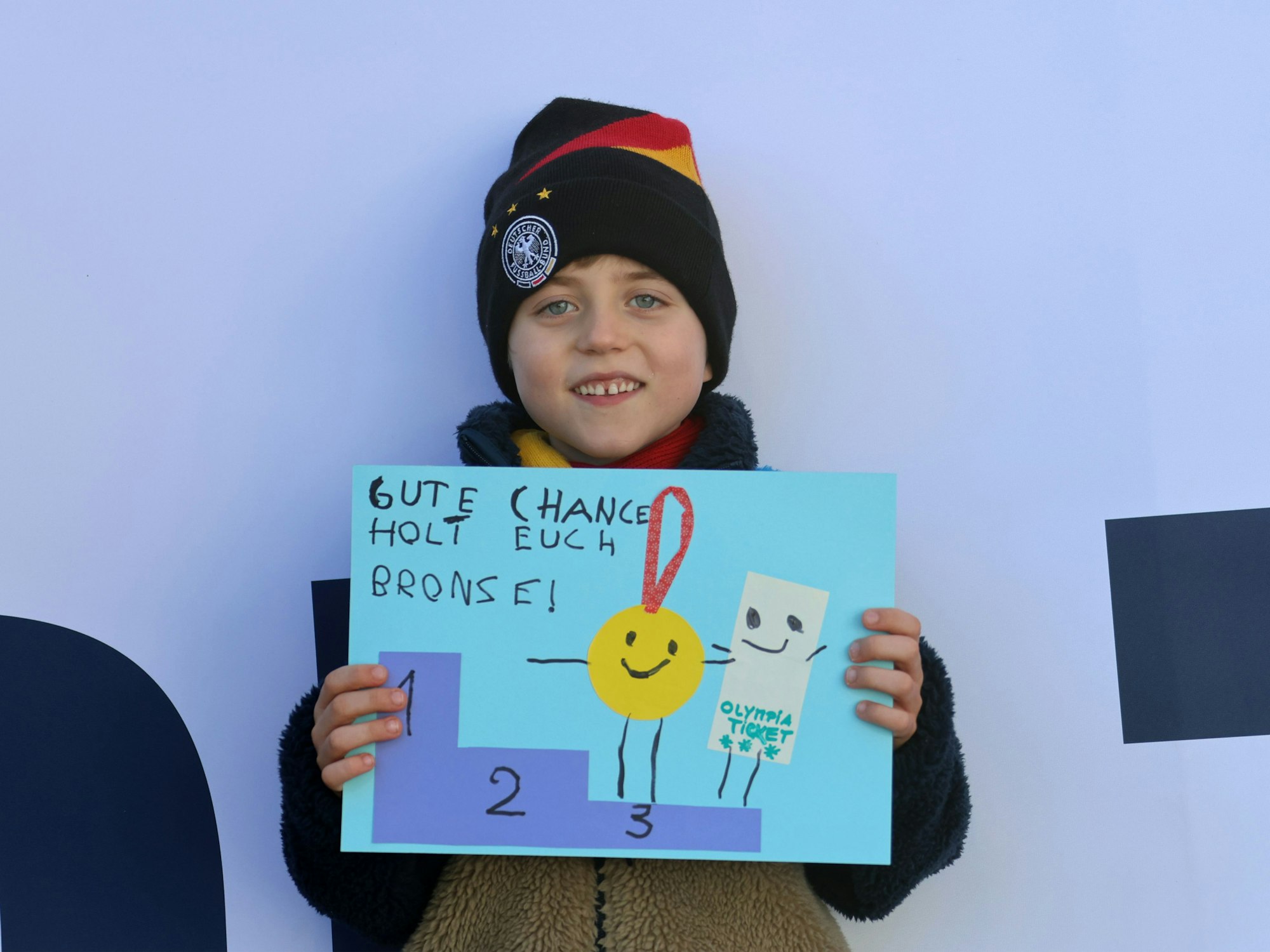 Bent steht mit Schild vor Arena.