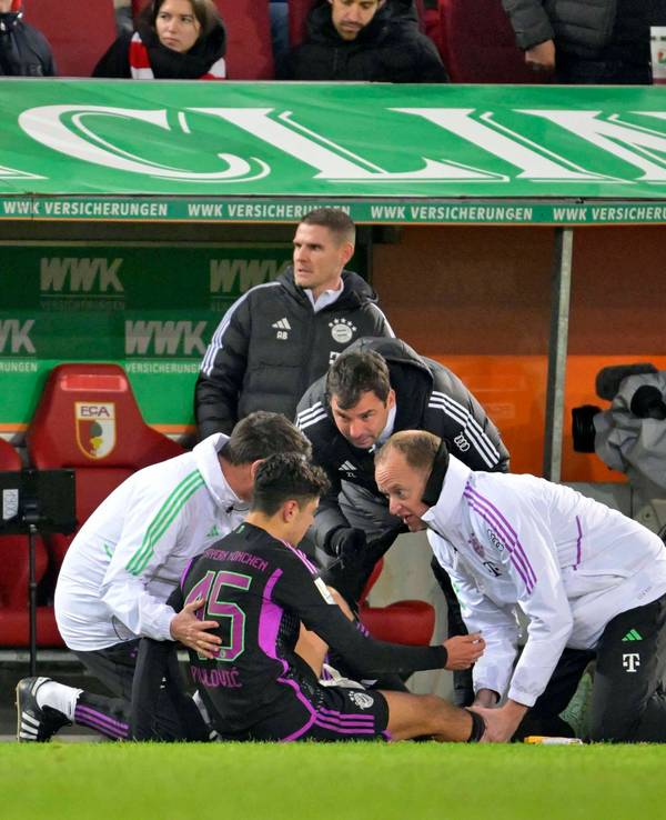 Während Aleksandar Pavlovic behandelt wird, guckt Thomas Tuchel aufgebracht Richtung Augsburg-Bank.
