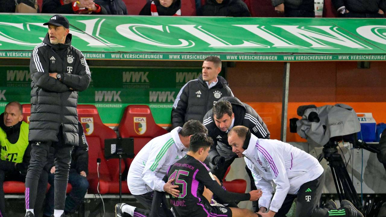 Während Aleksandar Pavlovic behandelt wird, guckt Thomas Tuchel aufgebracht Richtung Augsburg-Bank.