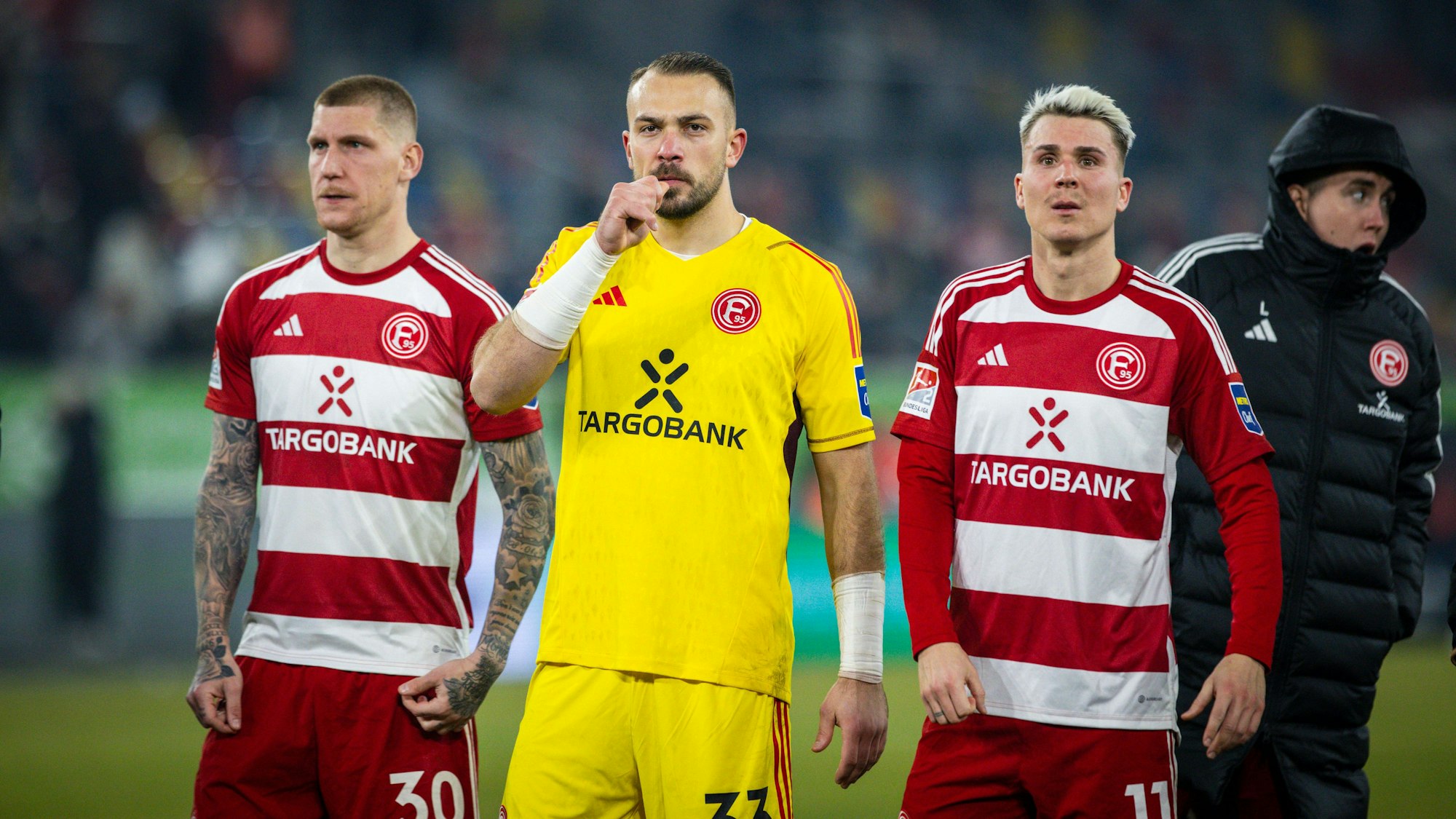 Die Fortuna-Düsseldorf-Spieler Jordy de Wijs, Florian Kastenmeier, Felix Klaus und Isak Johannesson stehen auf dem Platz. (Von l. nach r.)