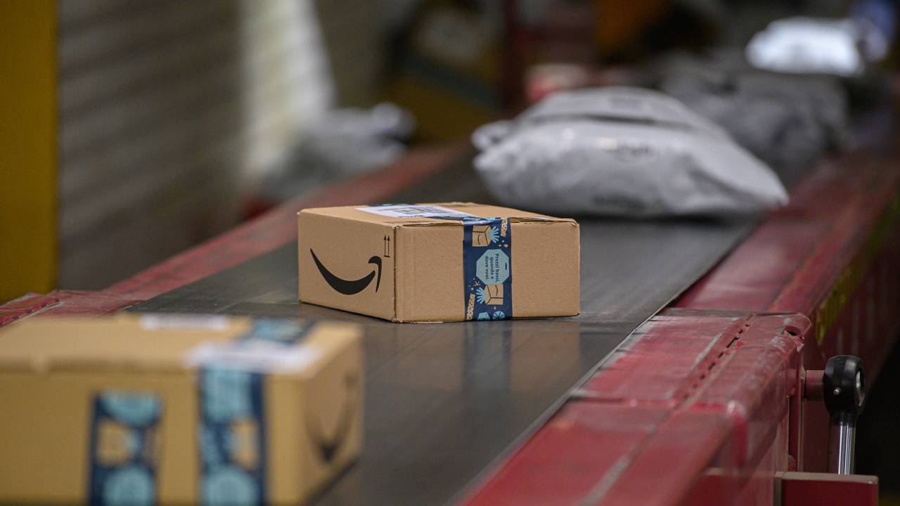Amazon Pakete liegen im DHL-Paketzentrum auf einem Transportband.