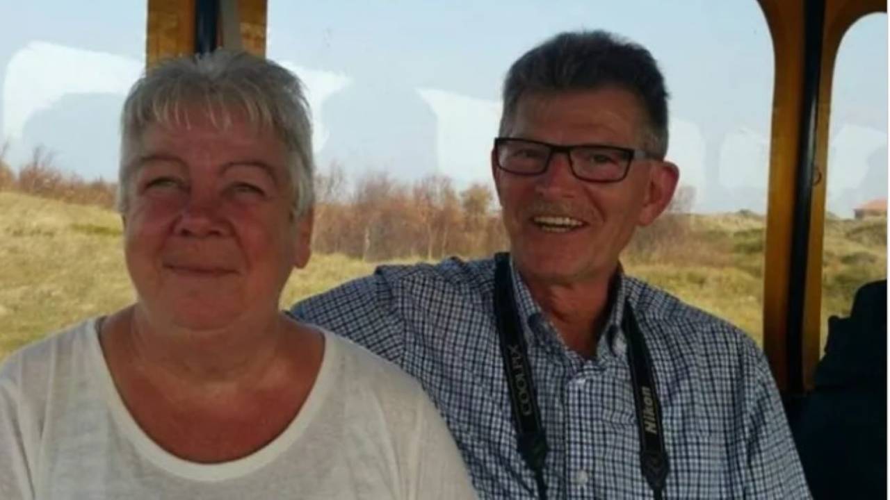 Richard Bitz legt seinen Arm um seine Frau Regina. Beide sitzen an einem Fenster mit Blick in die Natur.